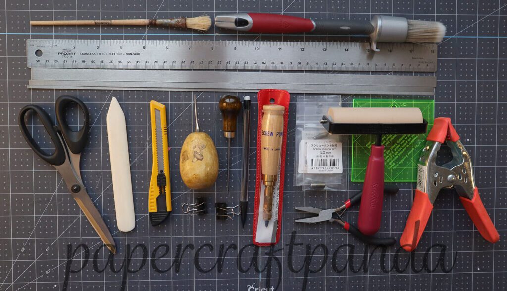 top down view of all the tools needed to make an adorable custom coupon book for couples using the japanese stab binding method