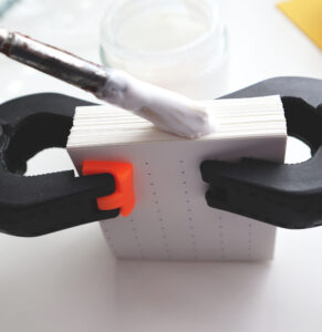 applying glue to the spine of a perfect binding using a paste brush