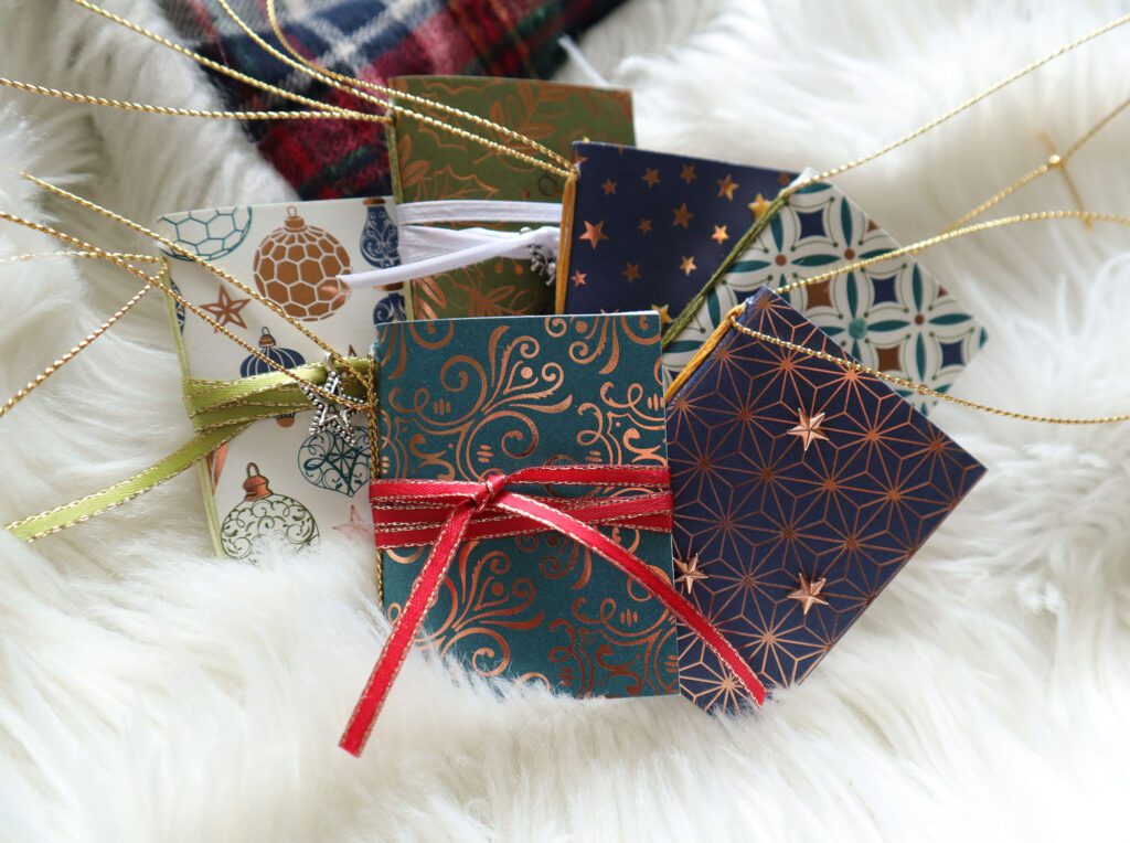 handmade mini book ornaments on a fluffy white christmas blanket