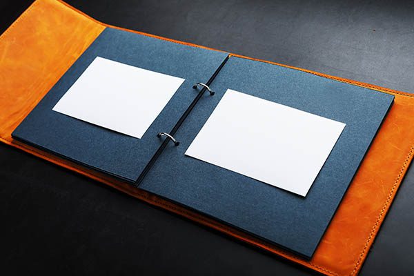 ring bound photo album with dark blue pages and orange cover