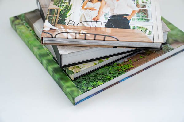 a stack of perfect bound photo book albums featuring family