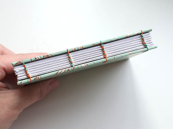 attaching the last board of a four needle coptic journal bookbinding tutorial